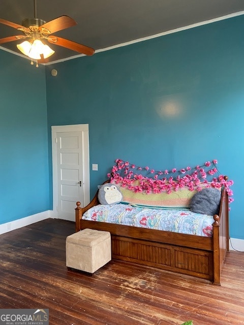 bedroom featuring ceiling fan, ornamental molding, and wood-type flooring