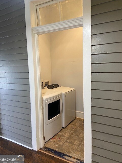 clothes washing area featuring dark wood-type flooring and washing machine and dryer