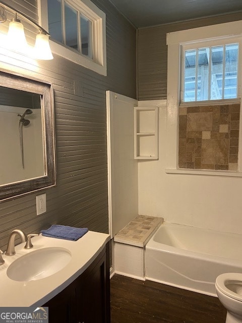 full bathroom with wood-type flooring, toilet, tub / shower combination, and vanity