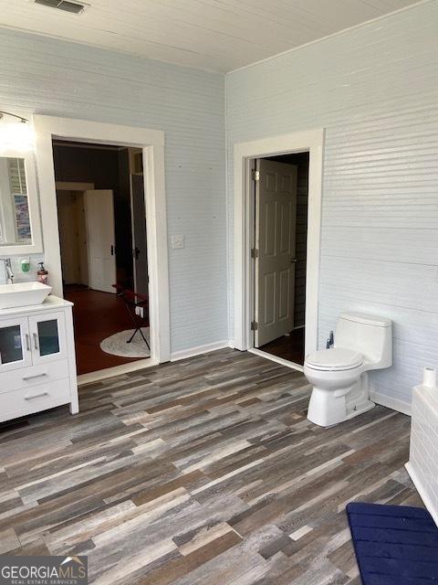 219 Main St E, Bronwood, GA 39826 - bathroom featuring vanity, visible vents, toilet, wood finished floors, and baseboards
