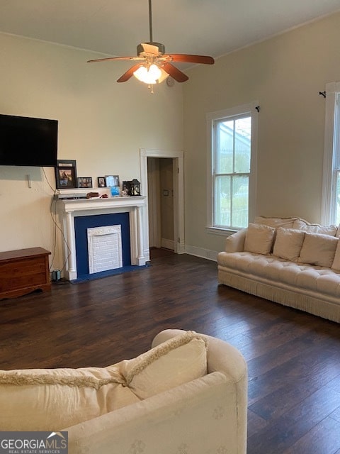 living room with dark hardwood / wood-style flooring and ceiling fan