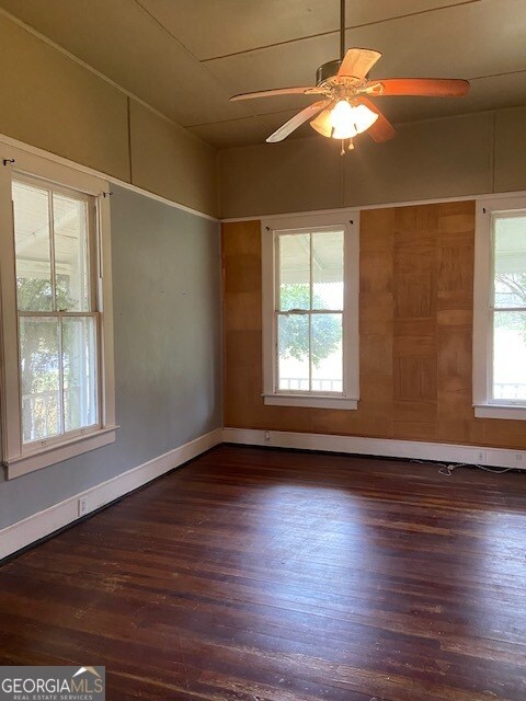 empty room featuring dark hardwood / wood-style flooring and ceiling fan