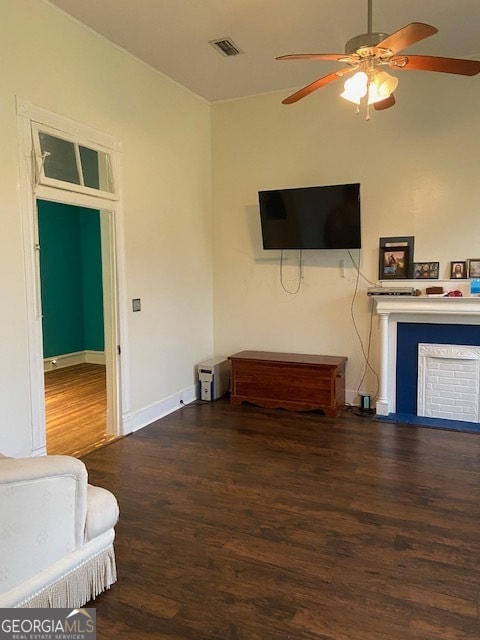 living room with ceiling fan and dark hardwood / wood-style flooring