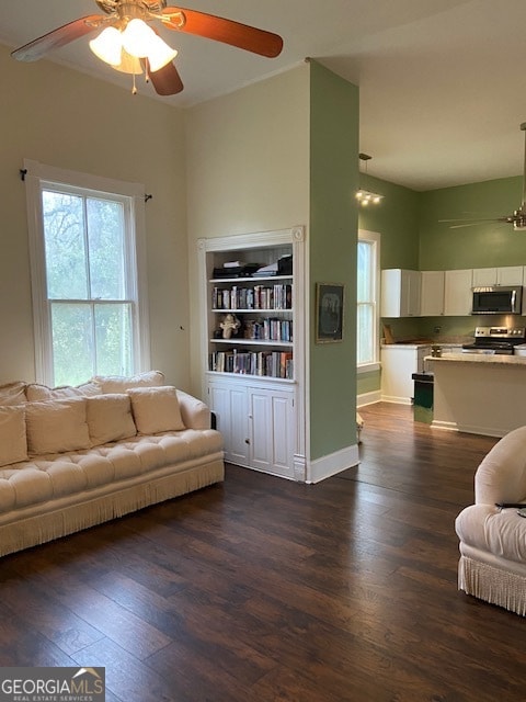 living room featuring ceiling fan and dark hardwood / wood-style flooring