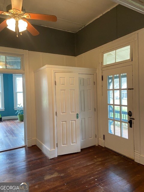 interior space with dark wood-type flooring, a wealth of natural light, and ceiling fan