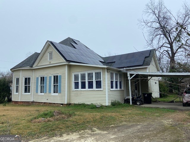 view of home's exterior with a yard and a carport