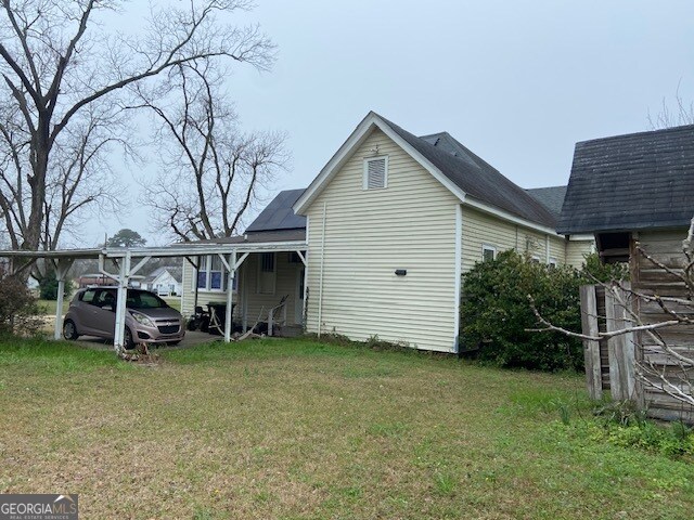 exterior space featuring a lawn and a carport