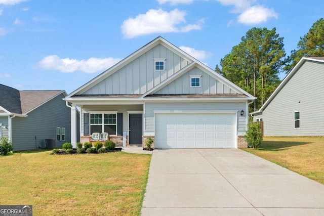 view of front of house featuring a front yard, central AC, a garage, and covered porch