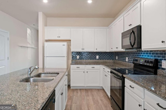 kitchen with black appliances, light stone counters, white cabinetry, and sink