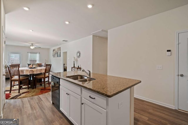 kitchen with sink, black dishwasher, dark stone counters, a kitchen island with sink, and white cabinets