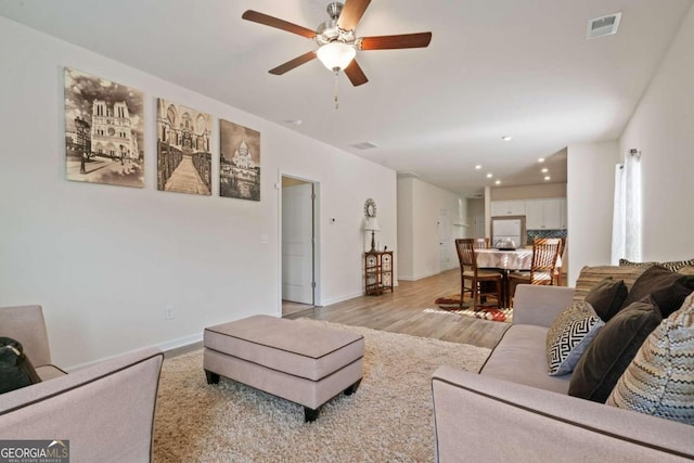 living room featuring light wood-type flooring and ceiling fan