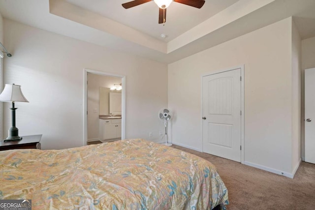 bedroom featuring carpet, ceiling fan, a raised ceiling, and ensuite bathroom