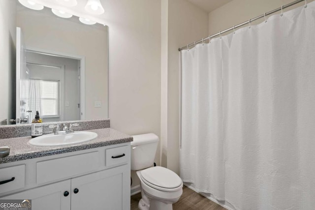 bathroom featuring hardwood / wood-style flooring, vanity, and toilet