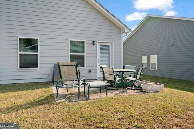 back of house with a patio area and a lawn