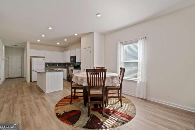 dining room featuring sink and light hardwood / wood-style floors