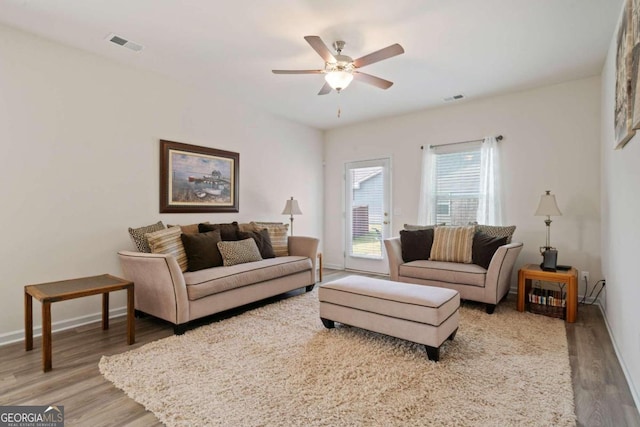 living room featuring ceiling fan and hardwood / wood-style flooring