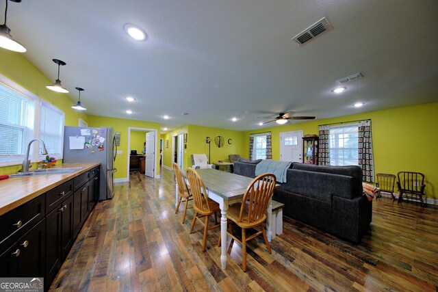 dining area featuring dark wood-type flooring, sink, and ceiling fan