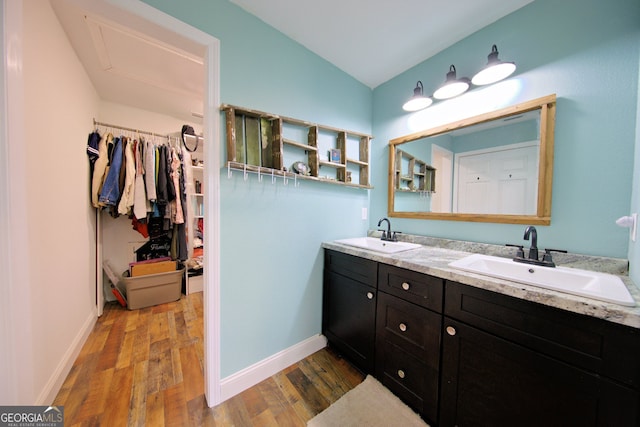 bathroom with lofted ceiling, hardwood / wood-style floors, and vanity