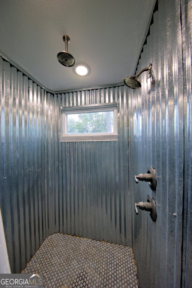 bathroom with a shower and a textured ceiling