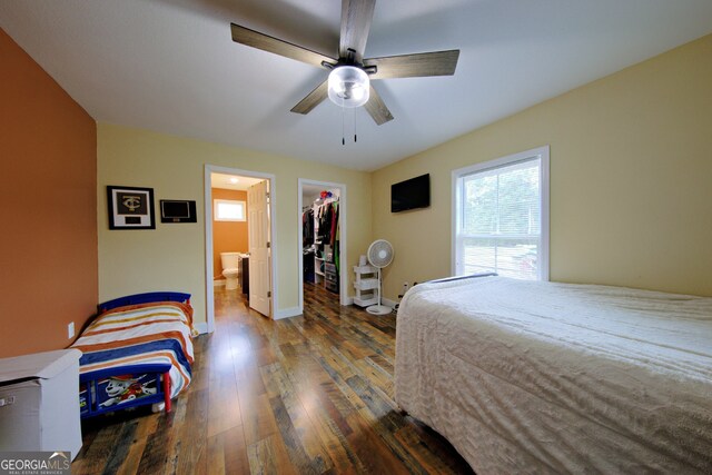 bedroom featuring a spacious closet, a closet, wood-type flooring, ensuite bathroom, and ceiling fan