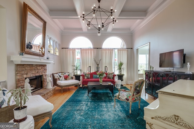 living room featuring a fireplace, plenty of natural light, wood-type flooring, and a chandelier