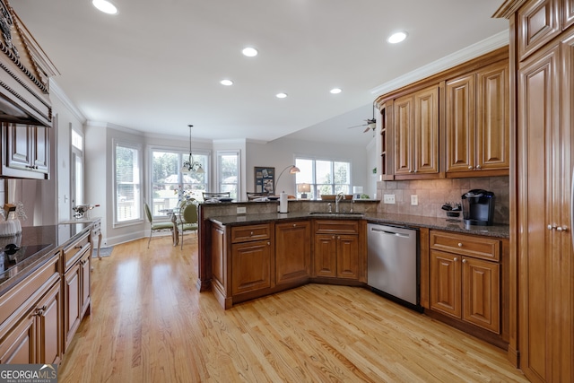 kitchen with decorative light fixtures, dishwasher, light hardwood / wood-style flooring, kitchen peninsula, and sink