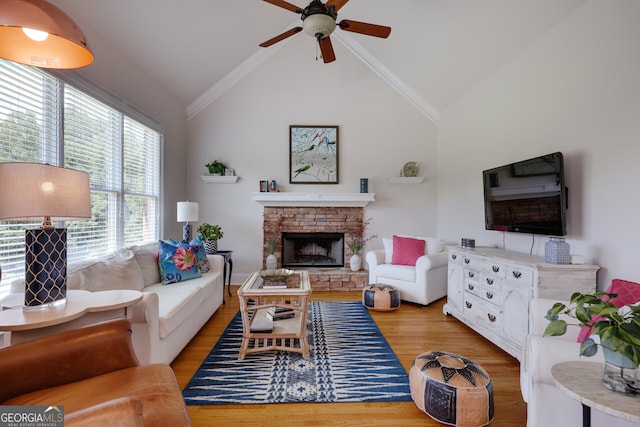 living room with ceiling fan, ornamental molding, light hardwood / wood-style floors, and vaulted ceiling