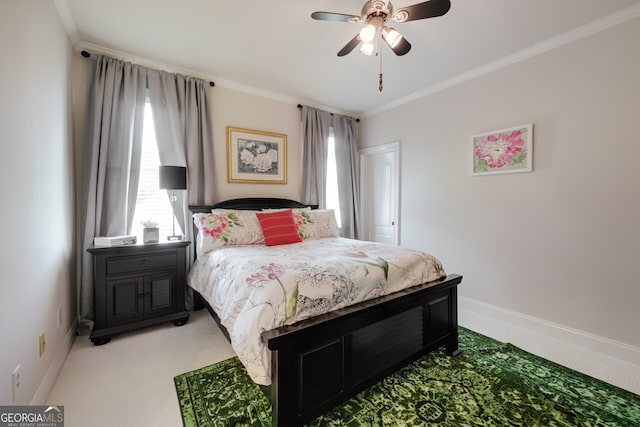 carpeted bedroom featuring ornamental molding and ceiling fan