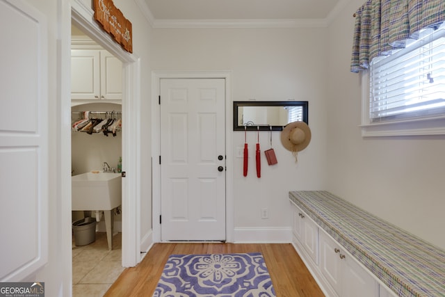 foyer entrance with crown molding and light hardwood / wood-style floors