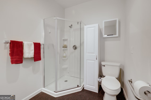 bathroom featuring toilet and a shower with door