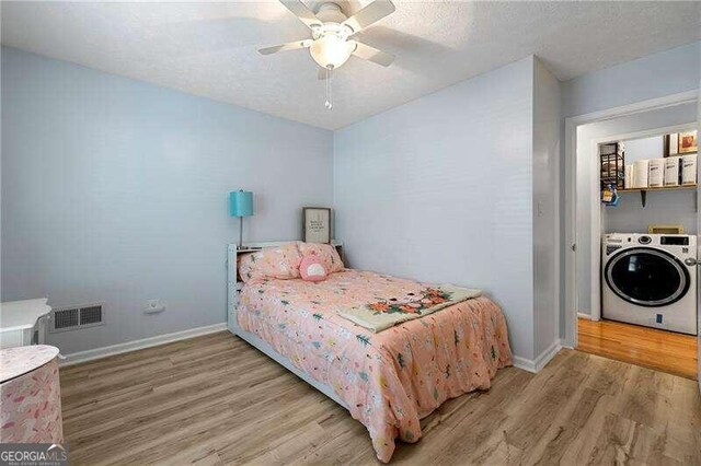 bedroom featuring a textured ceiling, ceiling fan, visible vents, baseboards, and light wood-type flooring