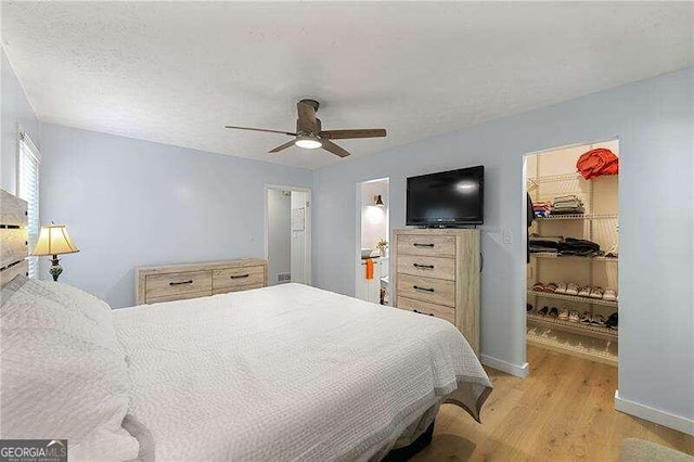 bedroom featuring light wood finished floors, visible vents, ceiling fan, a textured ceiling, and baseboards