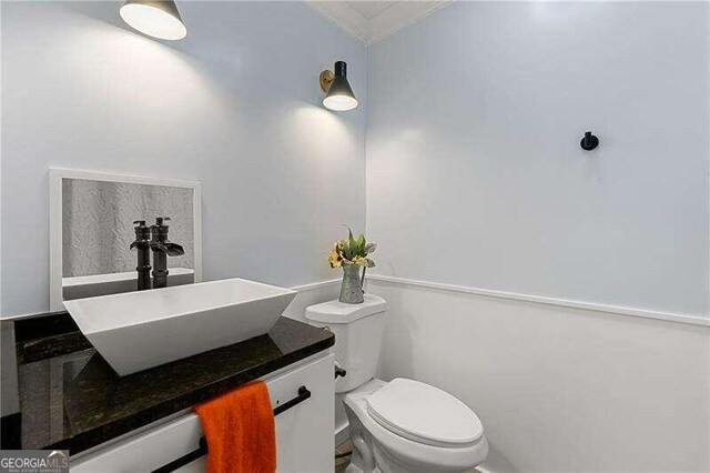 bathroom with shower / tub combo, crown molding, vanity, and toilet