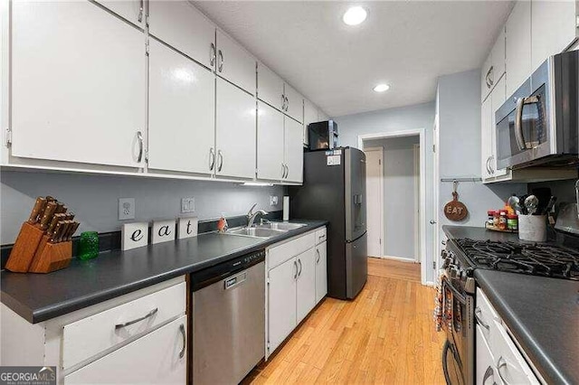 kitchen with stainless steel appliances, dark countertops, and white cabinets