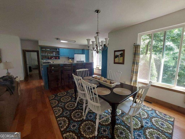 dining space with a notable chandelier and hardwood / wood-style flooring