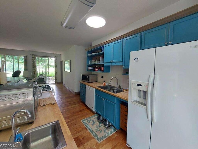 kitchen featuring white appliances, light hardwood / wood-style flooring, sink, and blue cabinetry