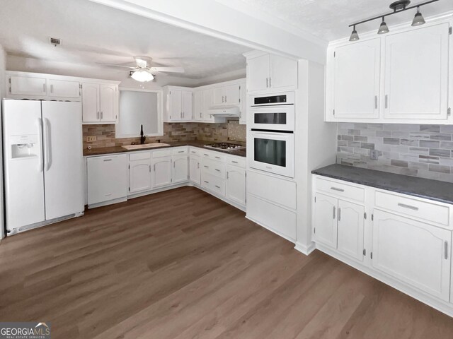 kitchen with a textured ceiling, dark stone countertops, tasteful backsplash, ceiling fan, and white cabinets