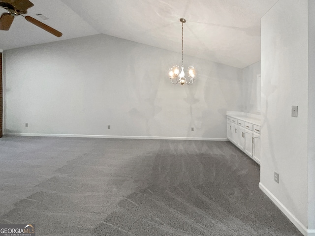 carpeted empty room with ceiling fan with notable chandelier and vaulted ceiling