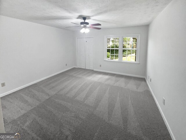 empty room featuring a healthy amount of sunlight, ceiling fan, and carpet