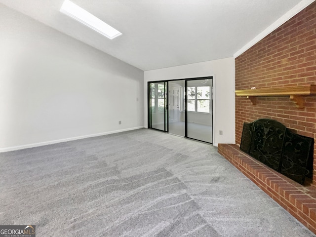 unfurnished living room featuring vaulted ceiling, light colored carpet, and a brick fireplace