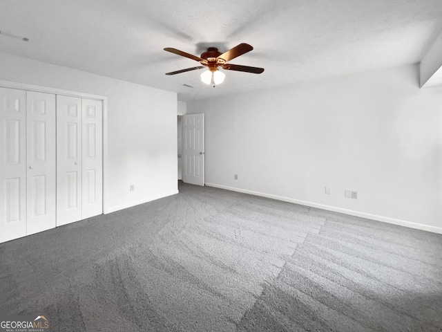 unfurnished bedroom with a closet, a textured ceiling, ceiling fan, and carpet floors