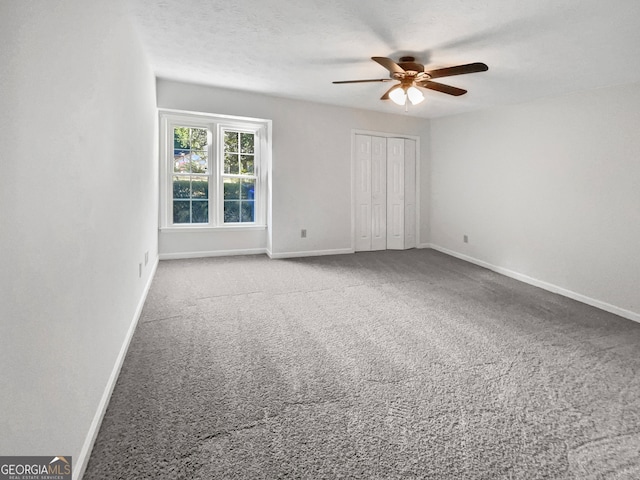 unfurnished room with carpet flooring, ceiling fan, and a textured ceiling