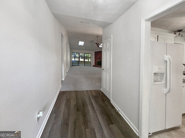 hallway featuring wood-type flooring and a textured ceiling