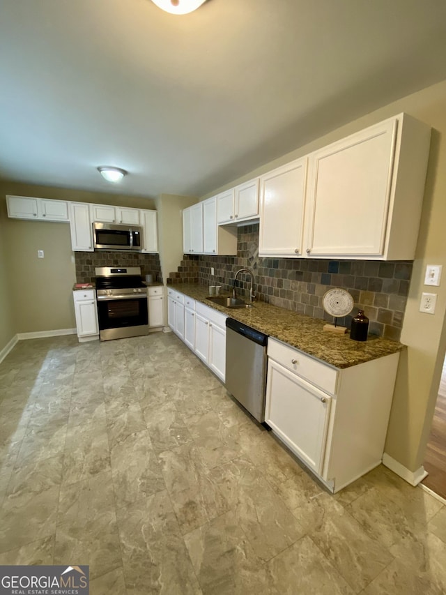 kitchen with sink, white cabinets, dark stone counters, and appliances with stainless steel finishes