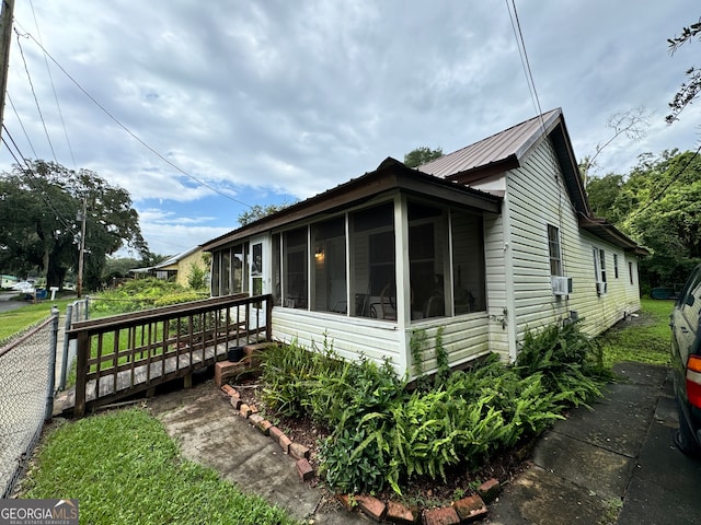 view of home's exterior with a sunroom