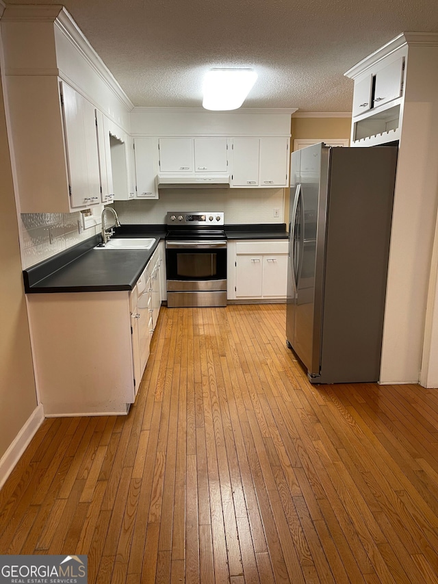 kitchen featuring stainless steel appliances, light hardwood / wood-style floors, white cabinetry, sink, and a textured ceiling