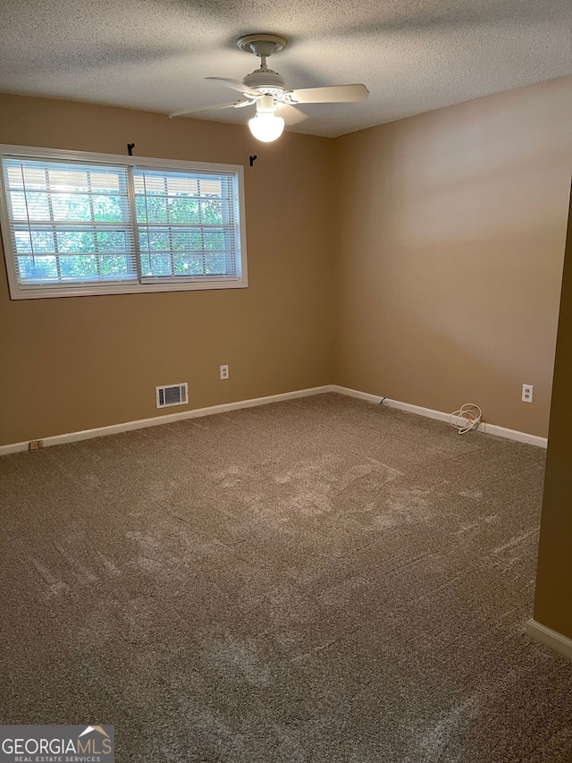 empty room with a textured ceiling, carpet, and ceiling fan