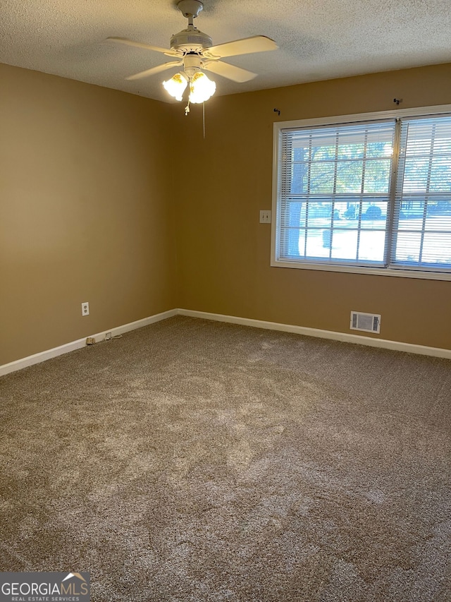 empty room featuring ceiling fan, a textured ceiling, and carpet floors