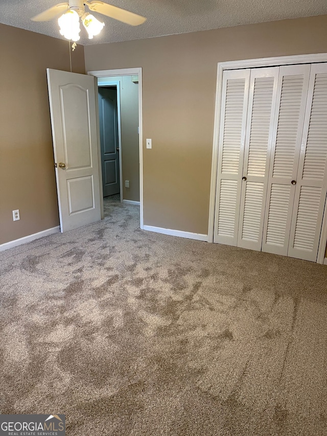 unfurnished bedroom featuring a textured ceiling, carpet, ceiling fan, and a closet