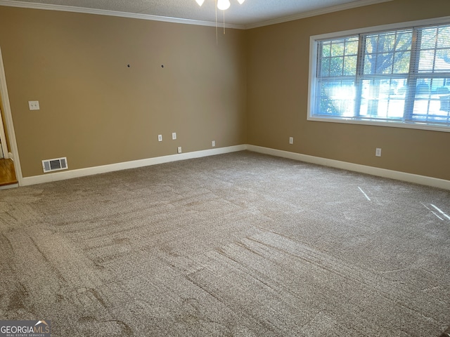 carpeted spare room featuring crown molding, a textured ceiling, and ceiling fan